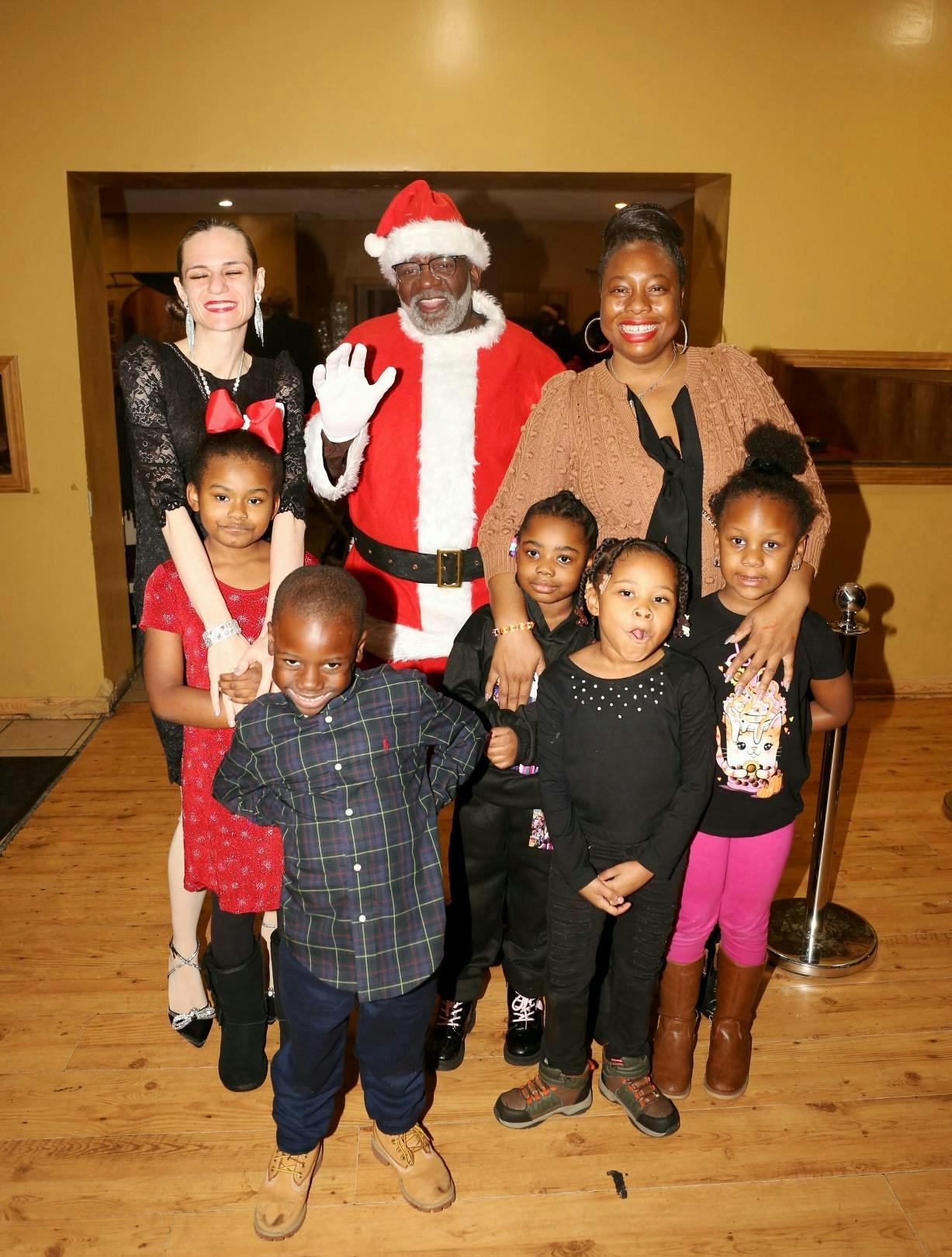 Adults and children posing with a person dressed as Santa