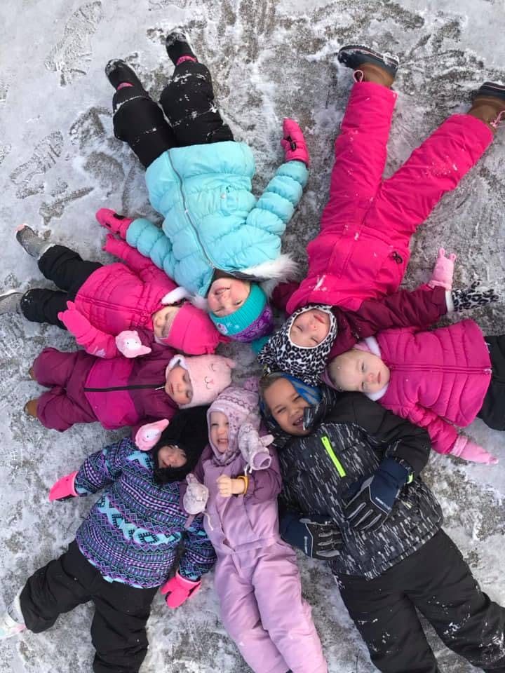 Group of children lying in a circle on the snow
