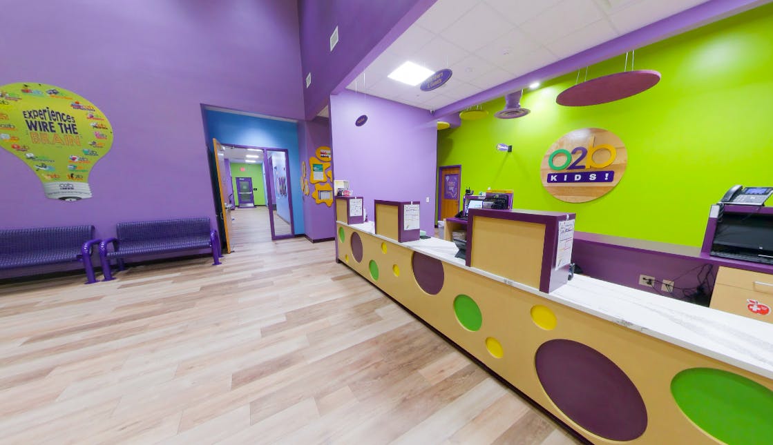 Reception desk with colorful decor and a sign that reads "O2 Kids"