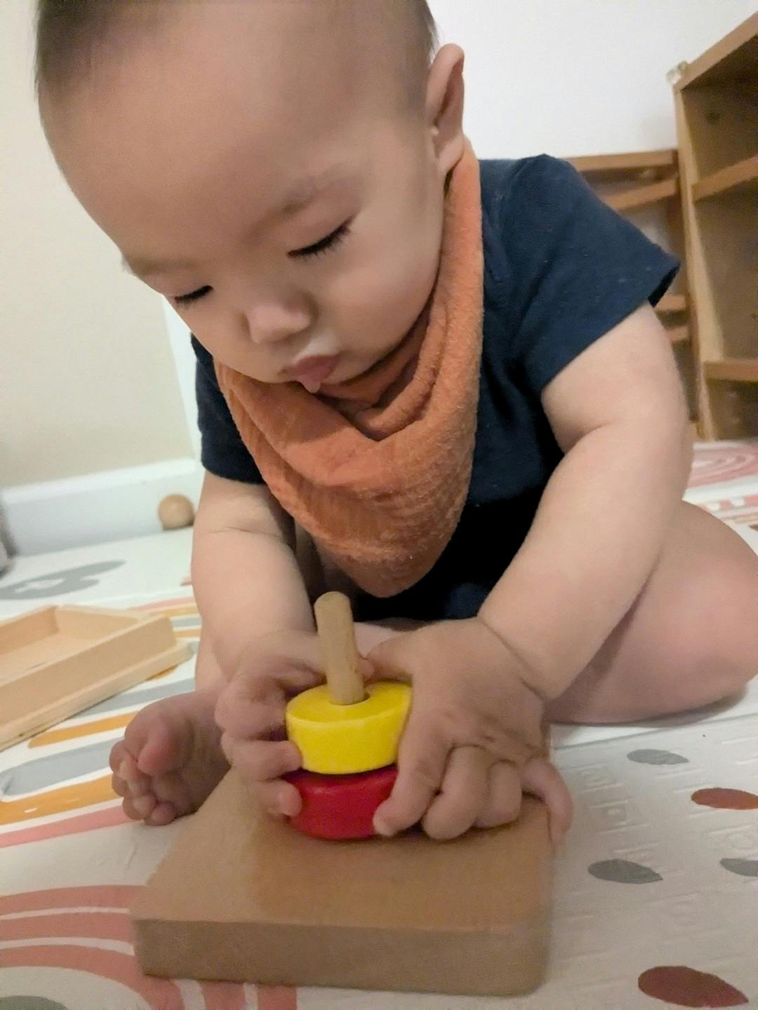 Child playing with a wooden stacking toy