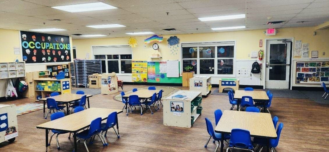 Empty preschool classroom with tables and chairs