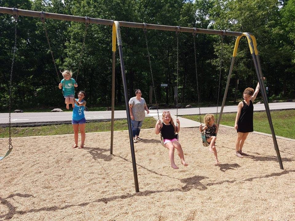 People on a swing set at a playground