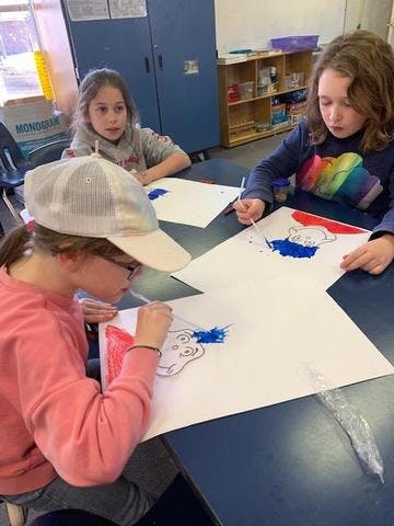 Three children painting at a table