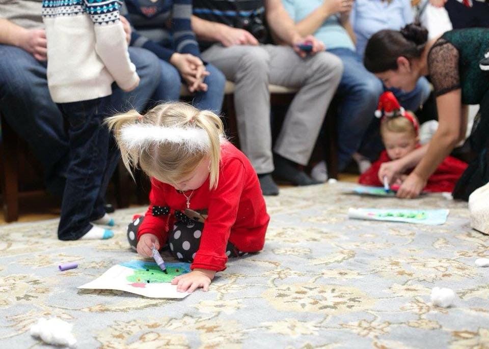 Child drawing on paper on the floor