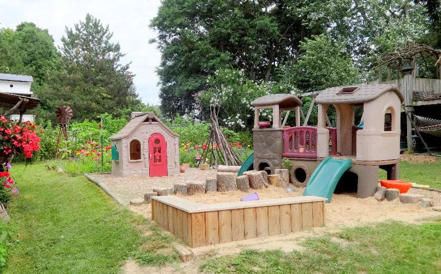 Playground with a playhouse, train-shaped play structure, and sandbox