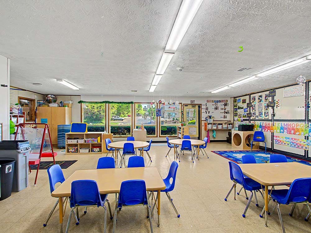 Classroom with small tables and blue chairs
