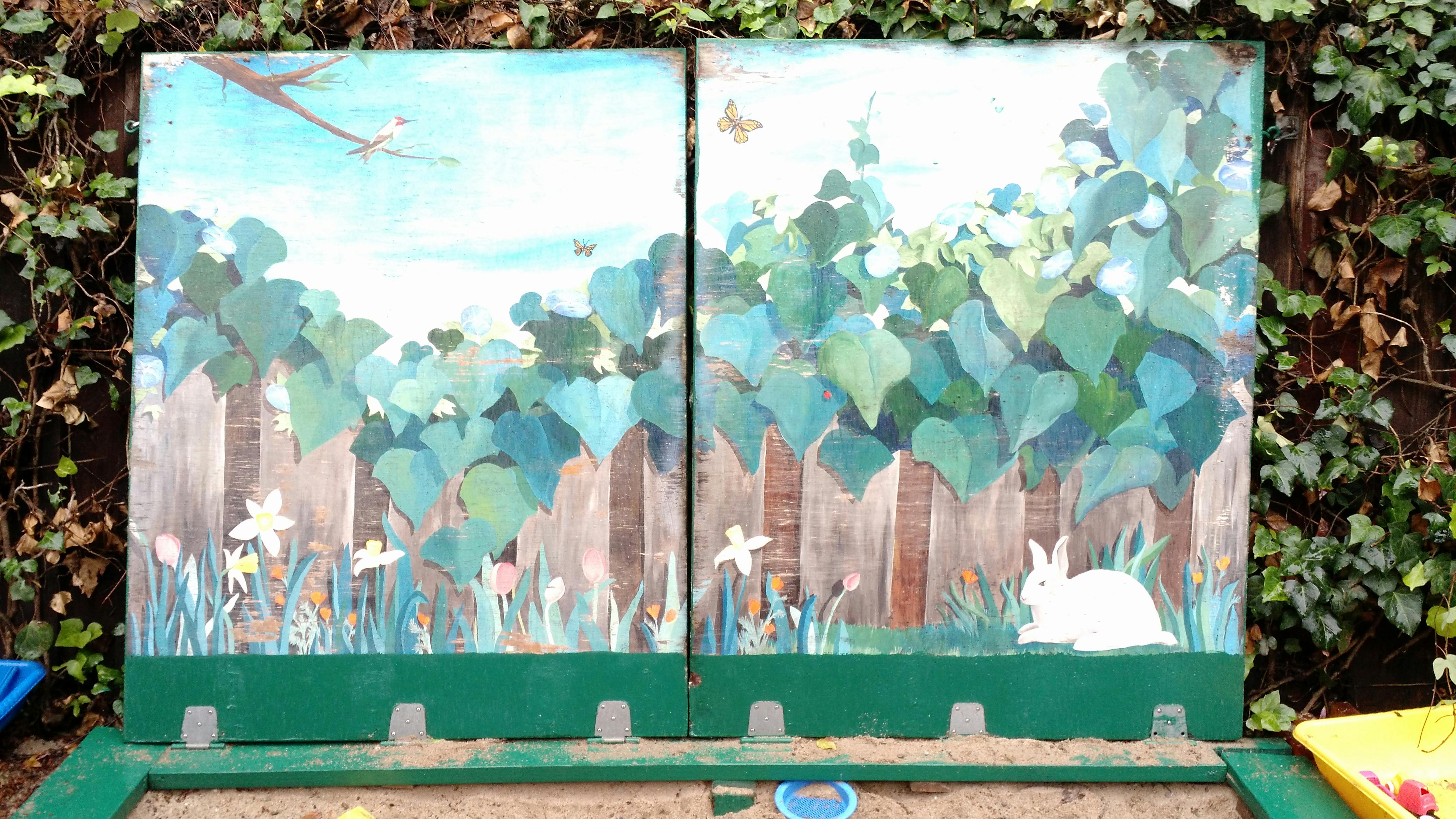 Mural of a fence with green foliage, flowers, and a white rabbit