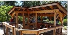 Wooden gazebo with open sides and a sloped roof
