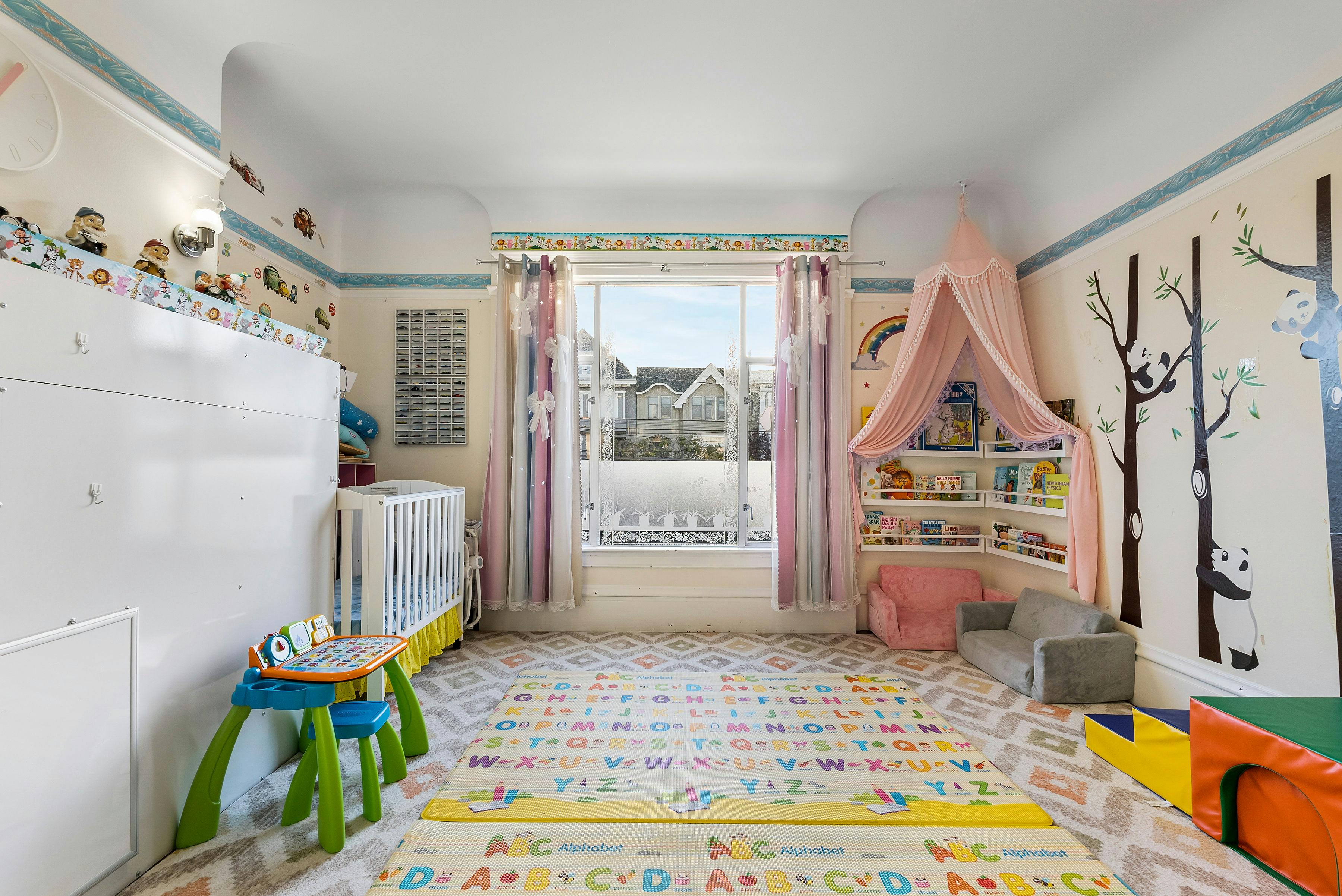 Child's room with crib, play table, and panda wall decals