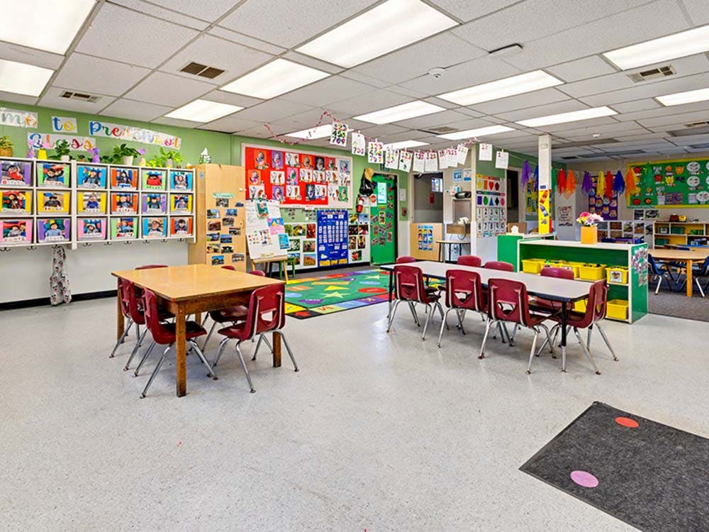 Colorful preschool classroom with tables and chairs