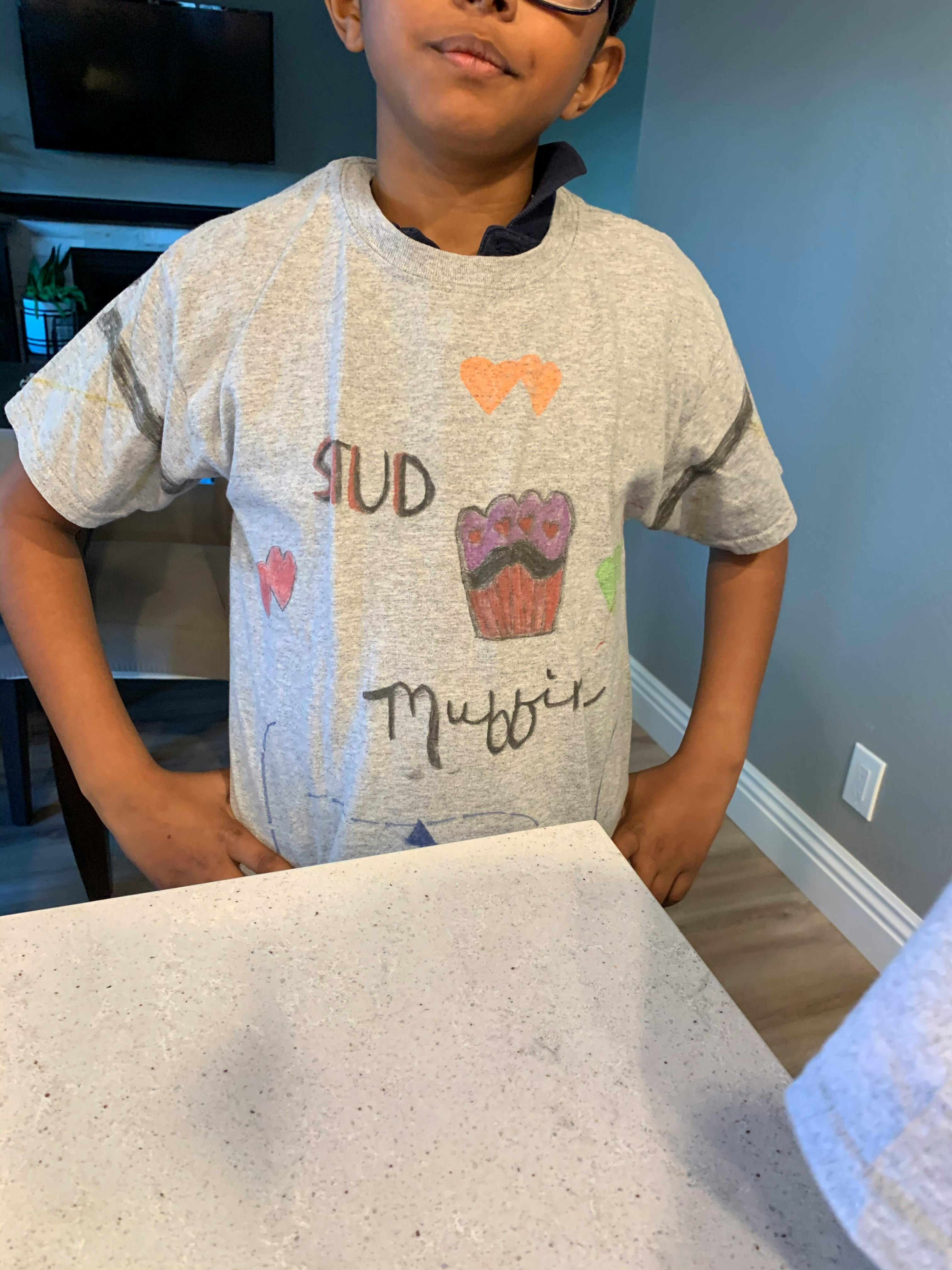 Child wearing a t-shirt with "STUD Muffin" and a cupcake graphic