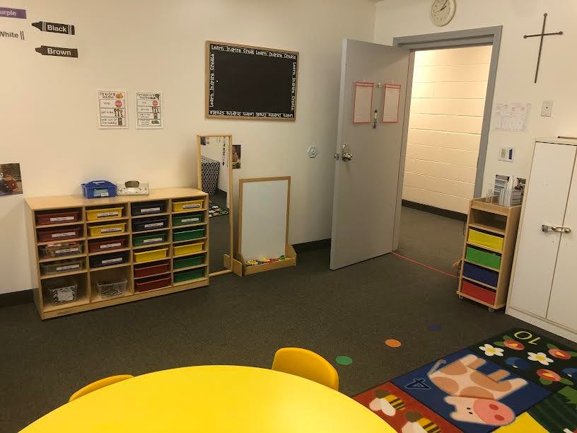 Classroom with storage shelves, chalkboard, and open door