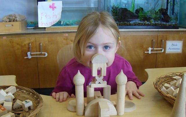 Child playing with wooden blocks at a table