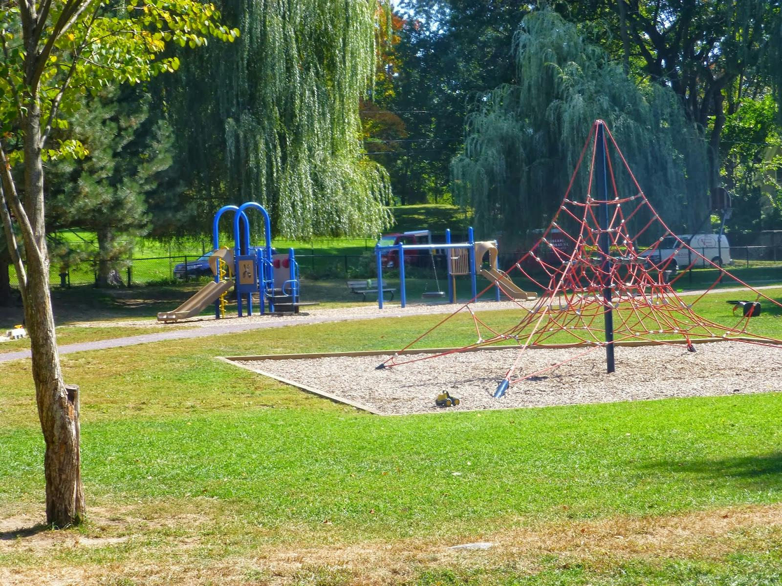 Playground with blue slides and a red rope climbing structure
