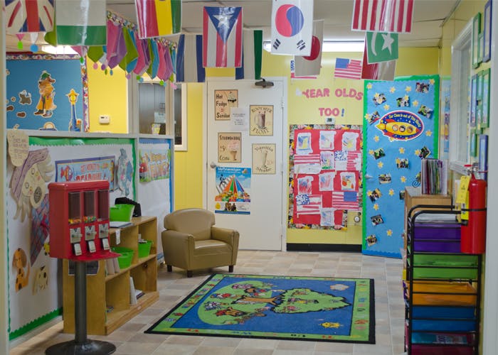 Classroom with flags, a world map rug, and various learning materials