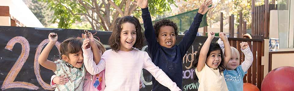 Group of children with arms raised