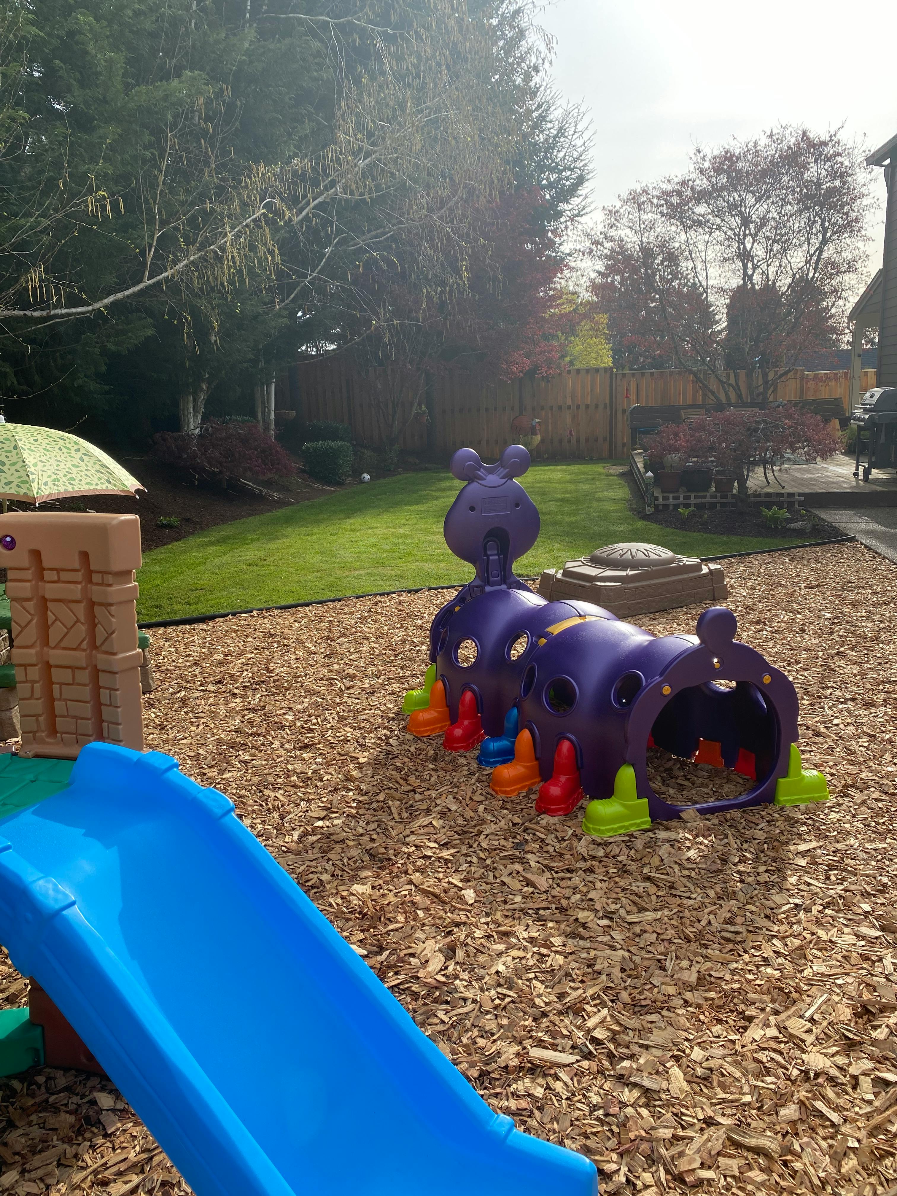 Playground with a blue slide and a purple caterpillar tunnel