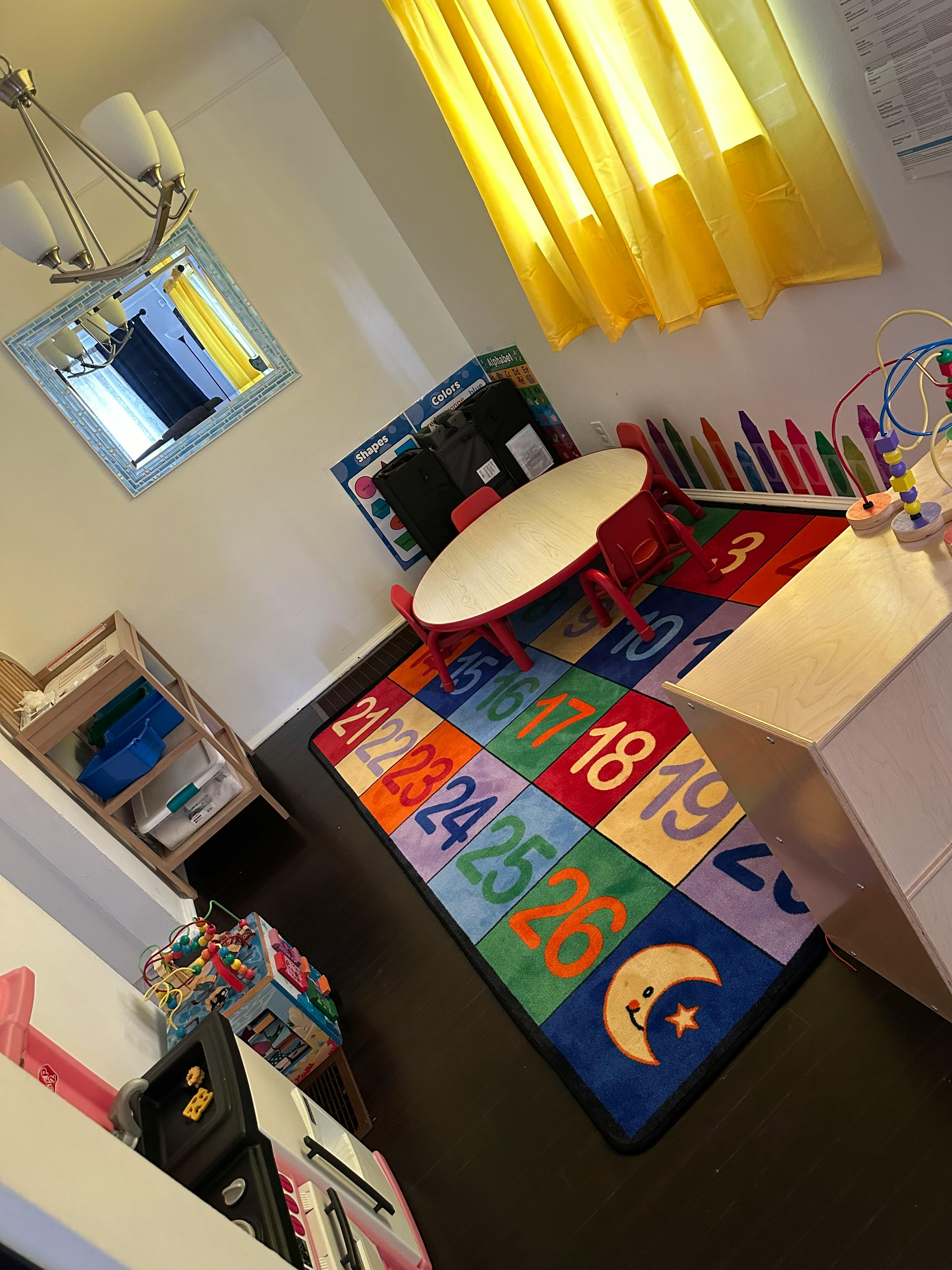 Children's play area with a colorful number rug and small table