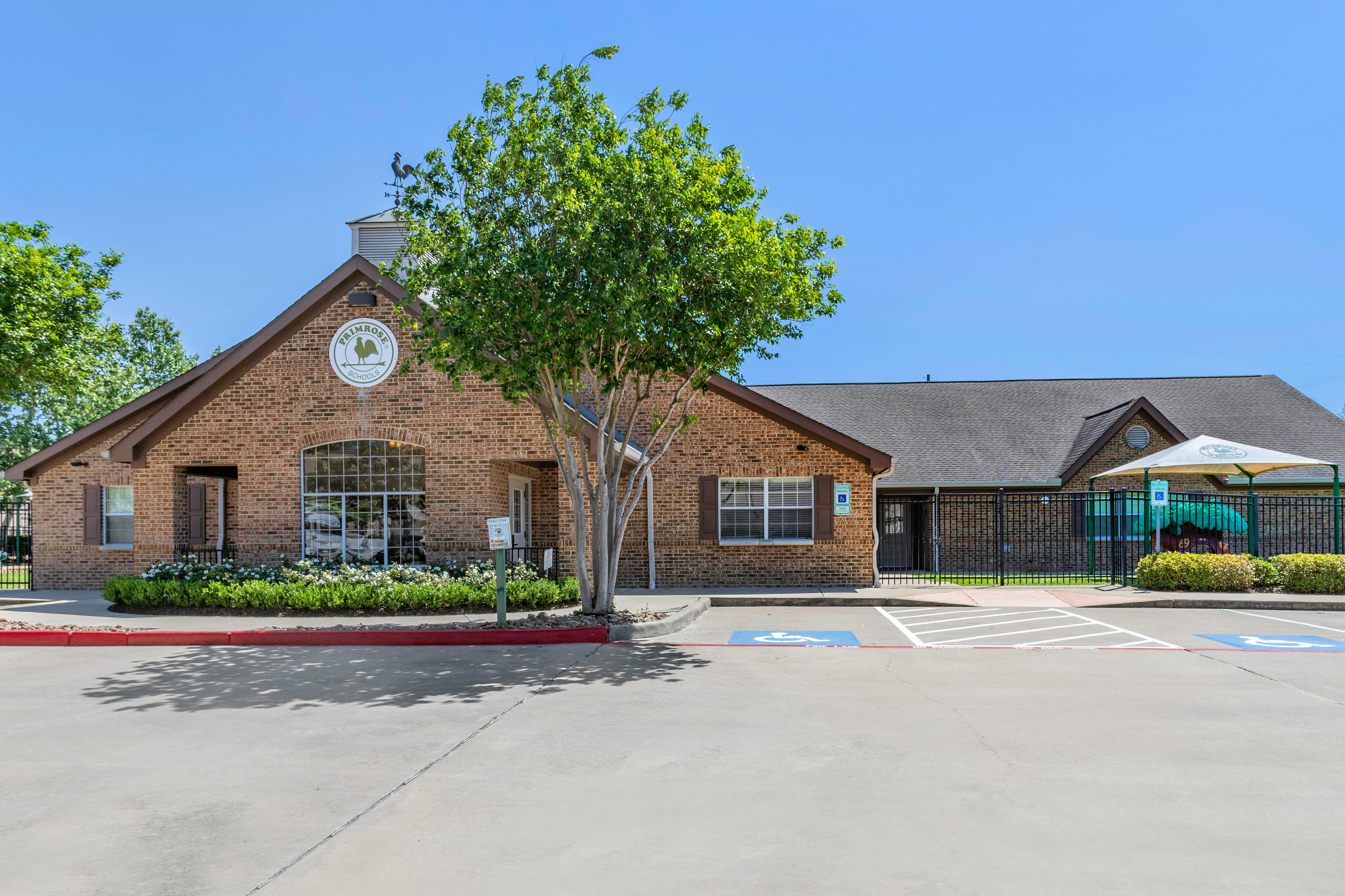 Brick building with a Primrose Schools sign and a tree in front