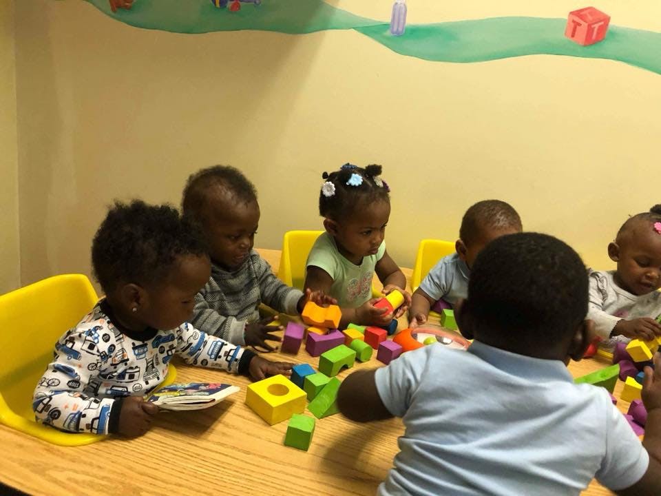 Multiple children playing with colorful blocks at a table