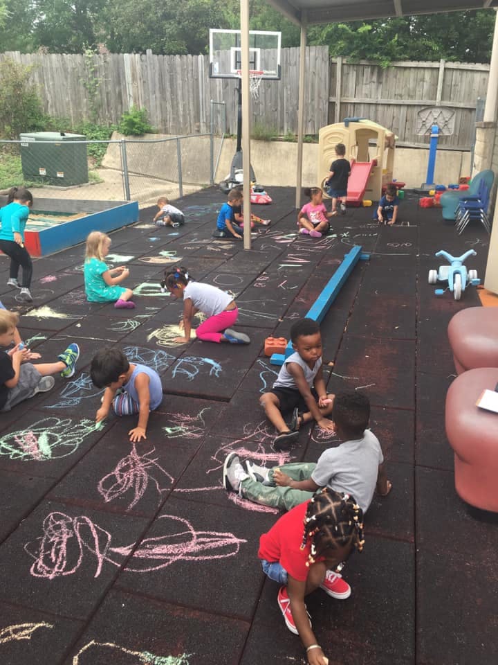 Children drawing with chalk on a playground