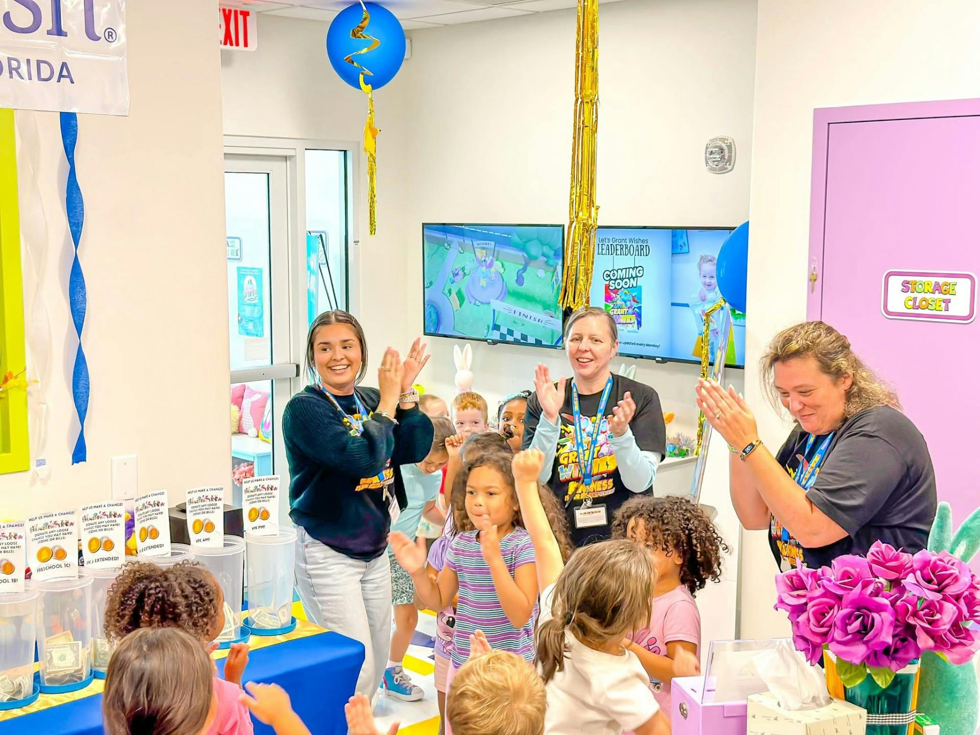 Adults and children clapping in a room