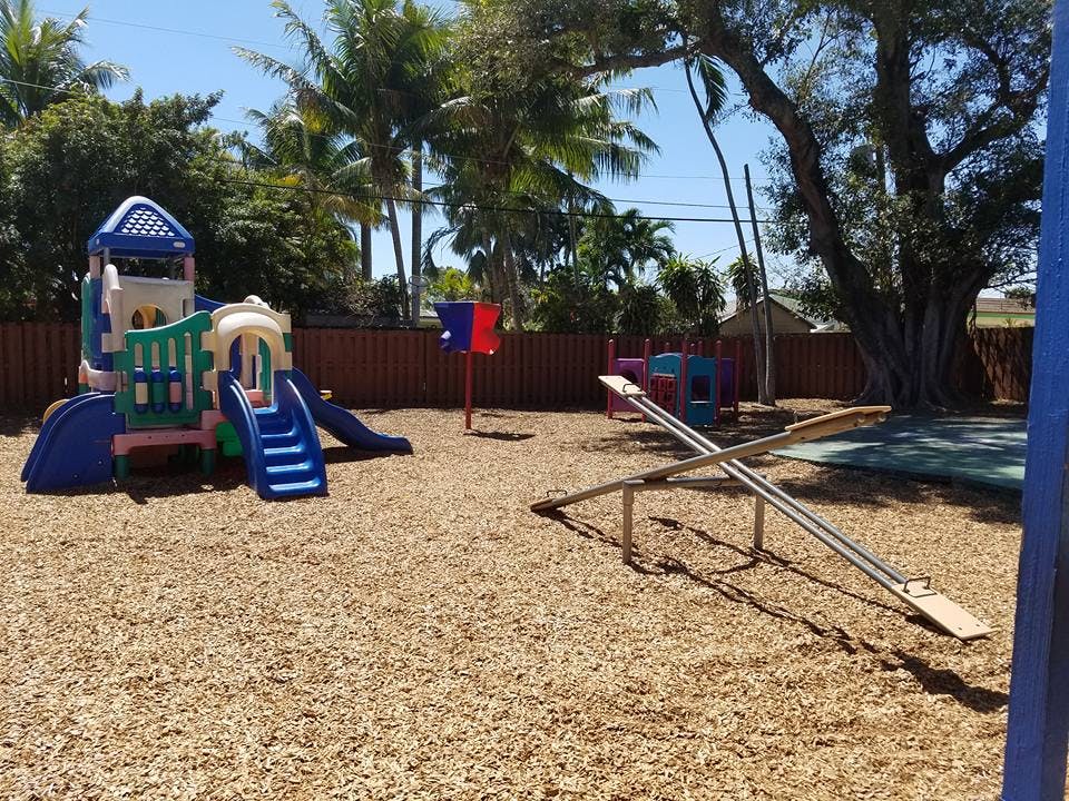 Playground with a play structure and a seesaw on wood chips