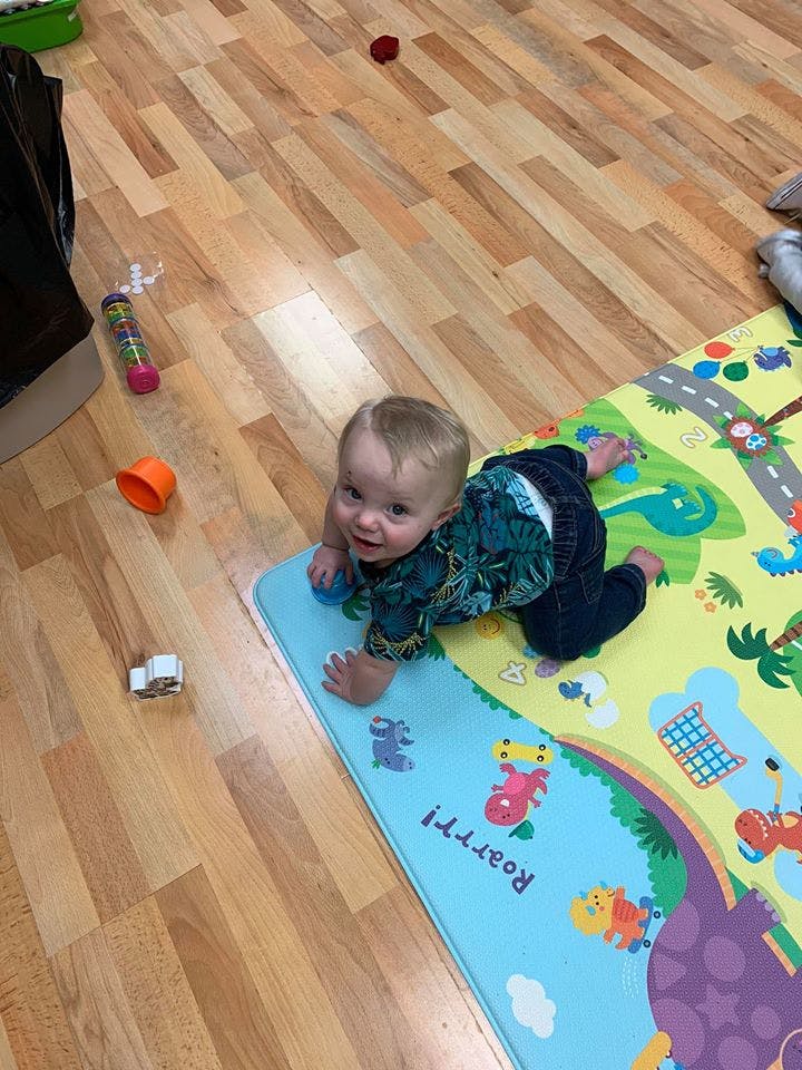Child crawling on a colorful playmat