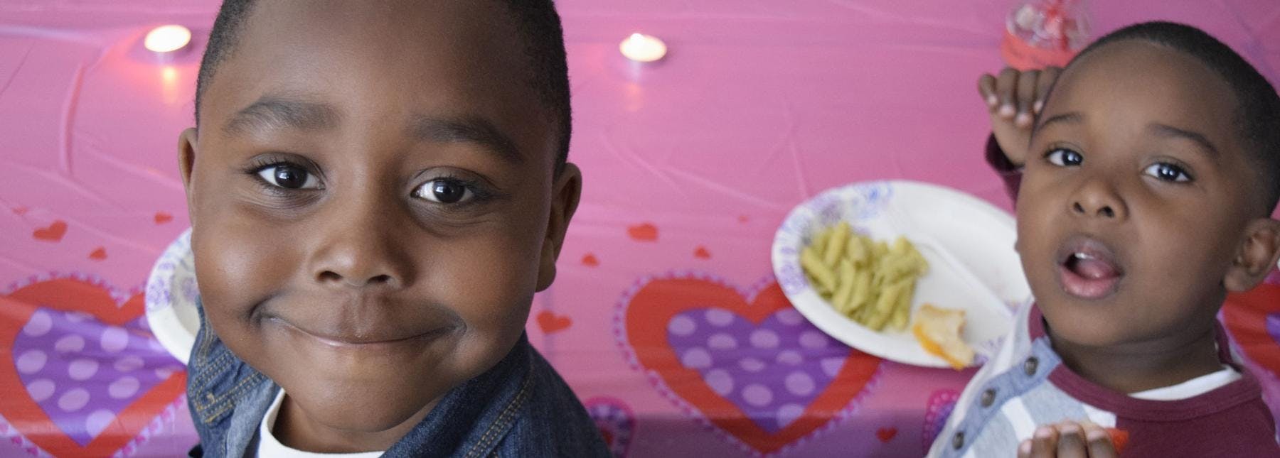Two children at a table with a plate of food