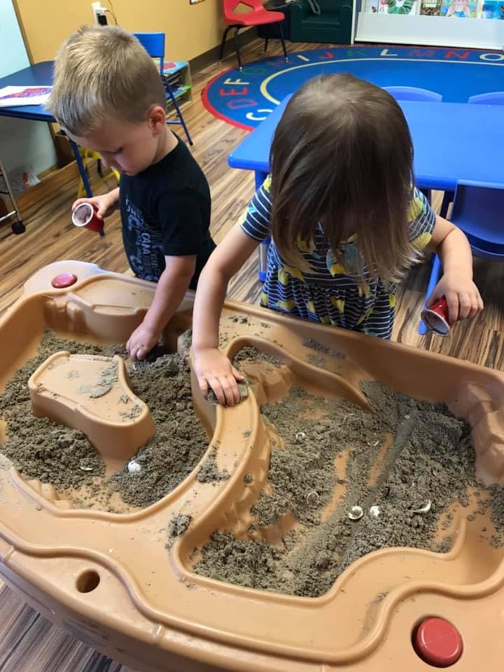 Two children playing in a sand table