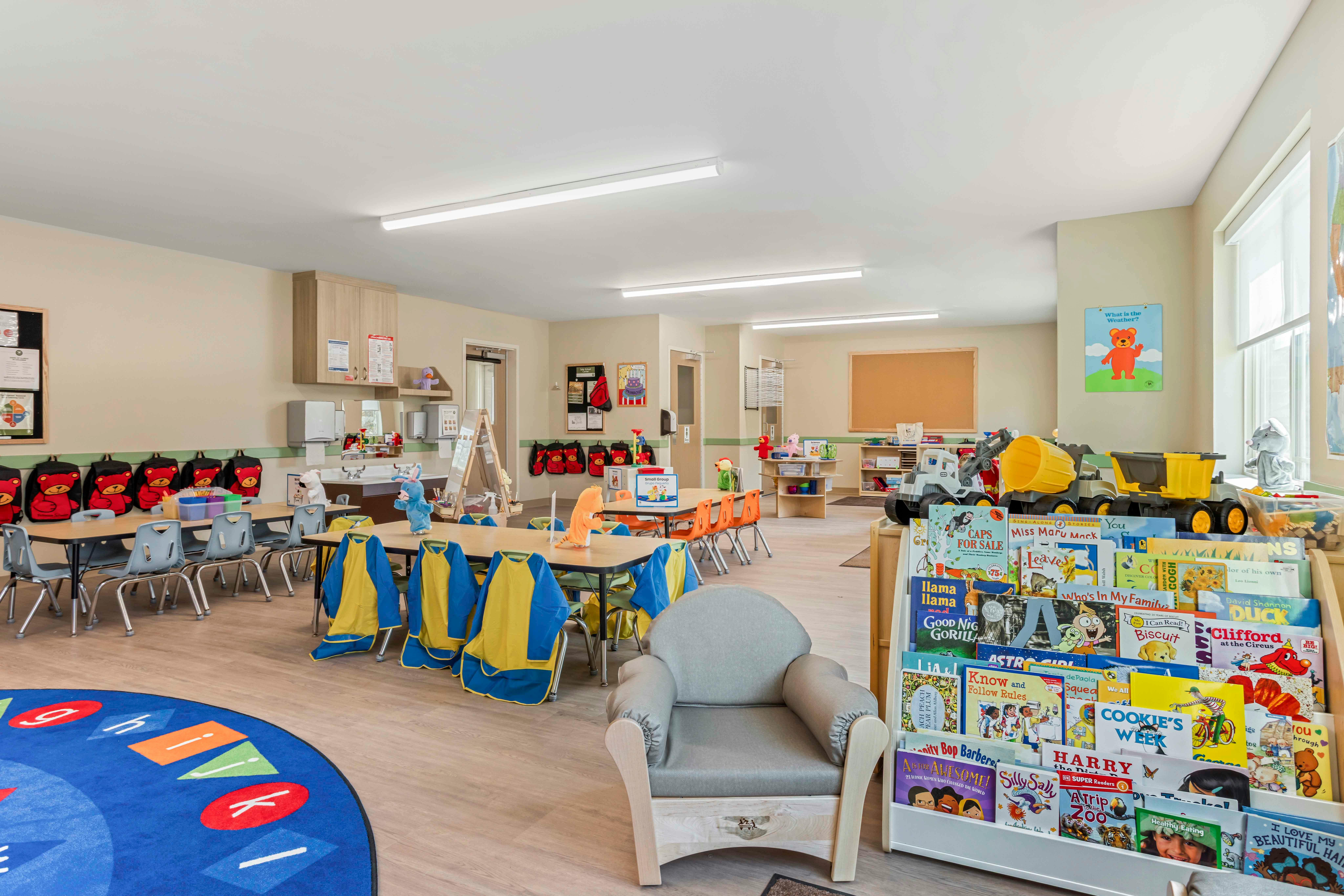 Classroom with child-sized tables, chairs, colorful supplies, and a book display