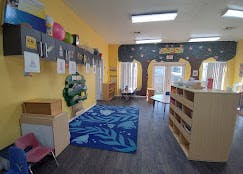 Empty classroom with yellow walls and a tree mural