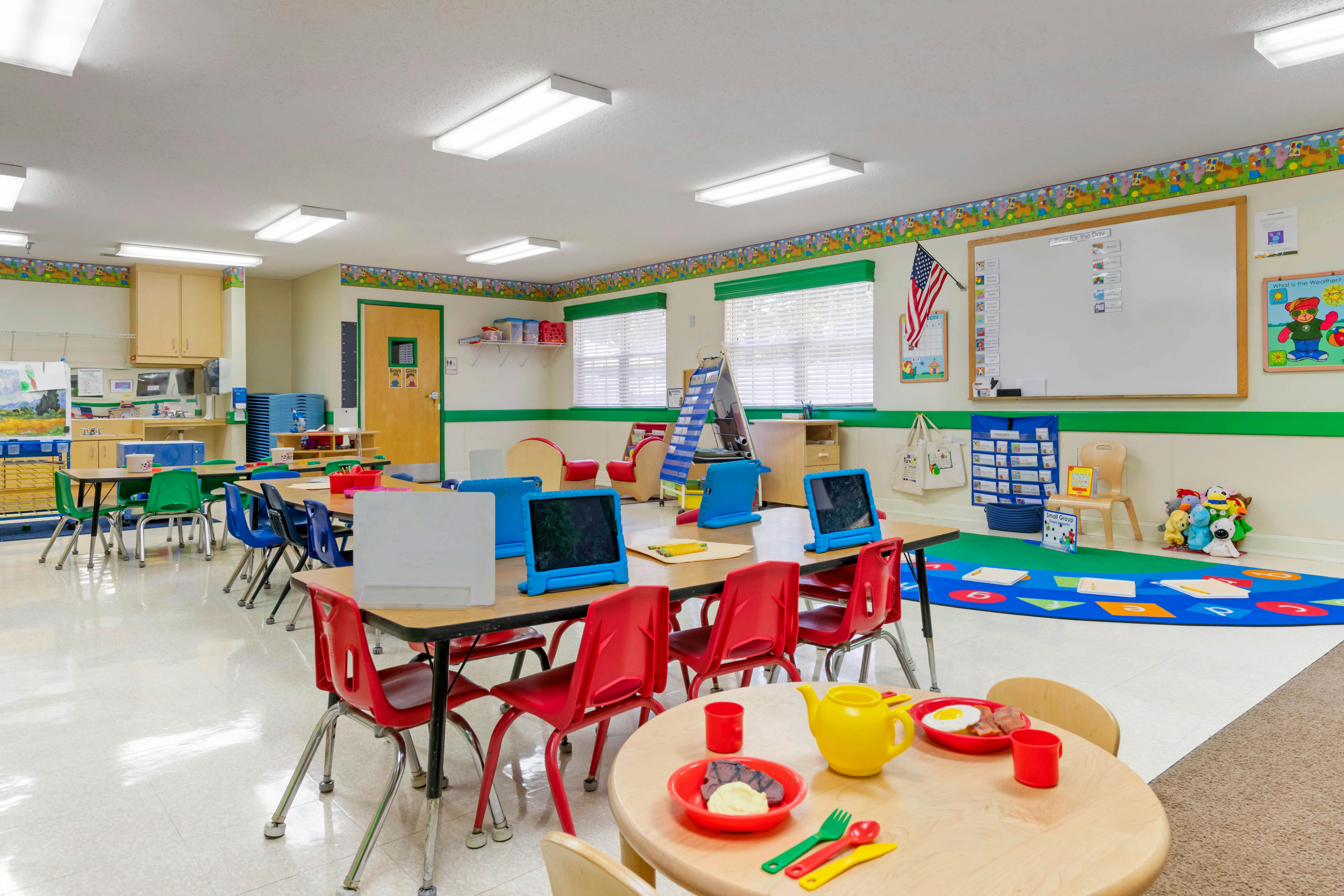 An empty early childhood classroom with colorful furniture and learning materials