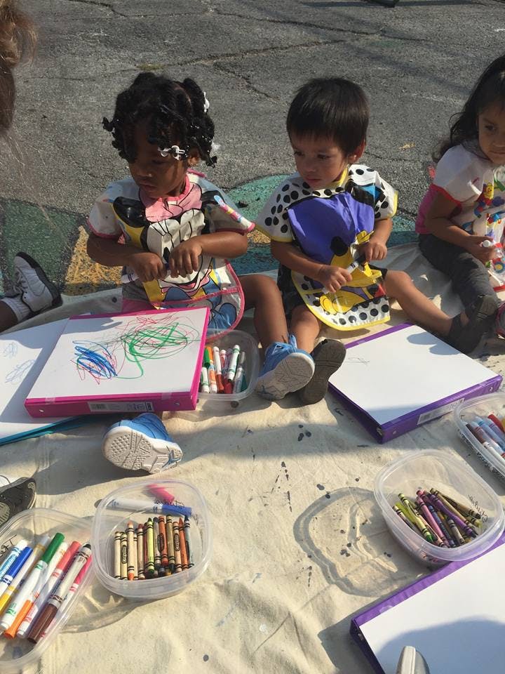 Two children drawing on paper with markers and crayons