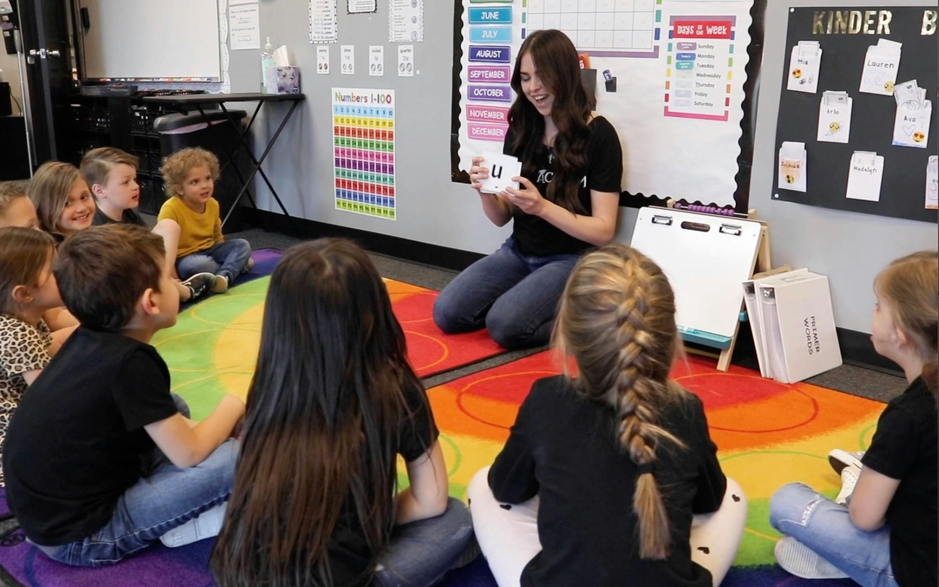Adult and children sitting on floor in classroom