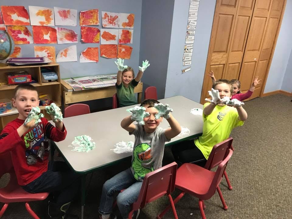 Children playing with shaving cream at a table