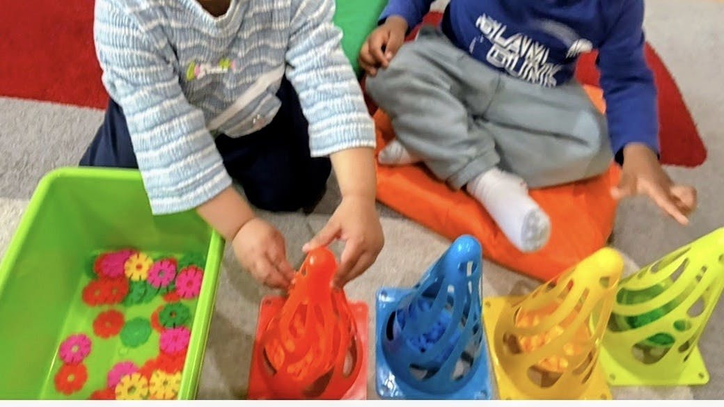 Two children playing with colorful sorting toys