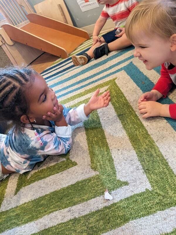 Two children playing on a rug