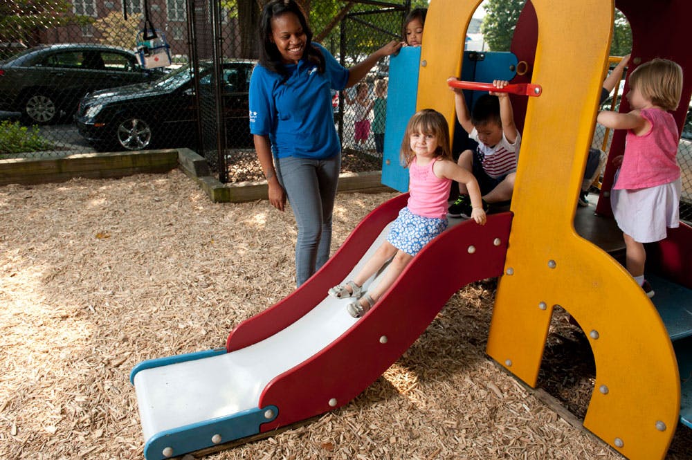 Adult and children on a playground slide