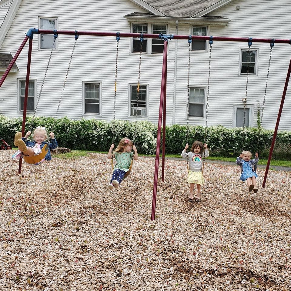 Four children on a swing set in a playground