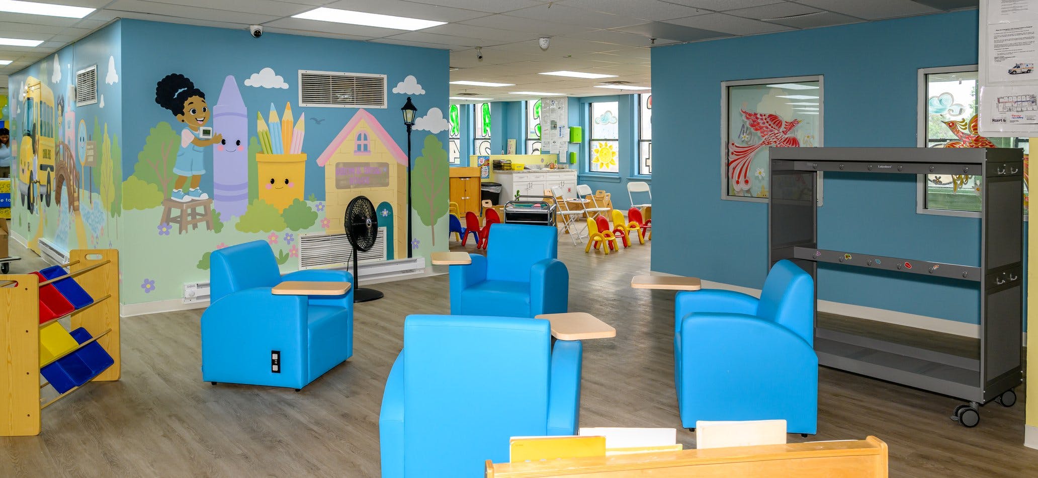 Blue armchairs in a colorful classroom with muraled walls