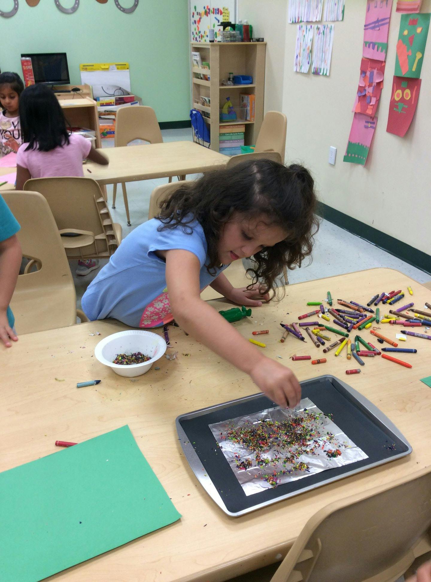 Child working on an art project with small colorful pieces