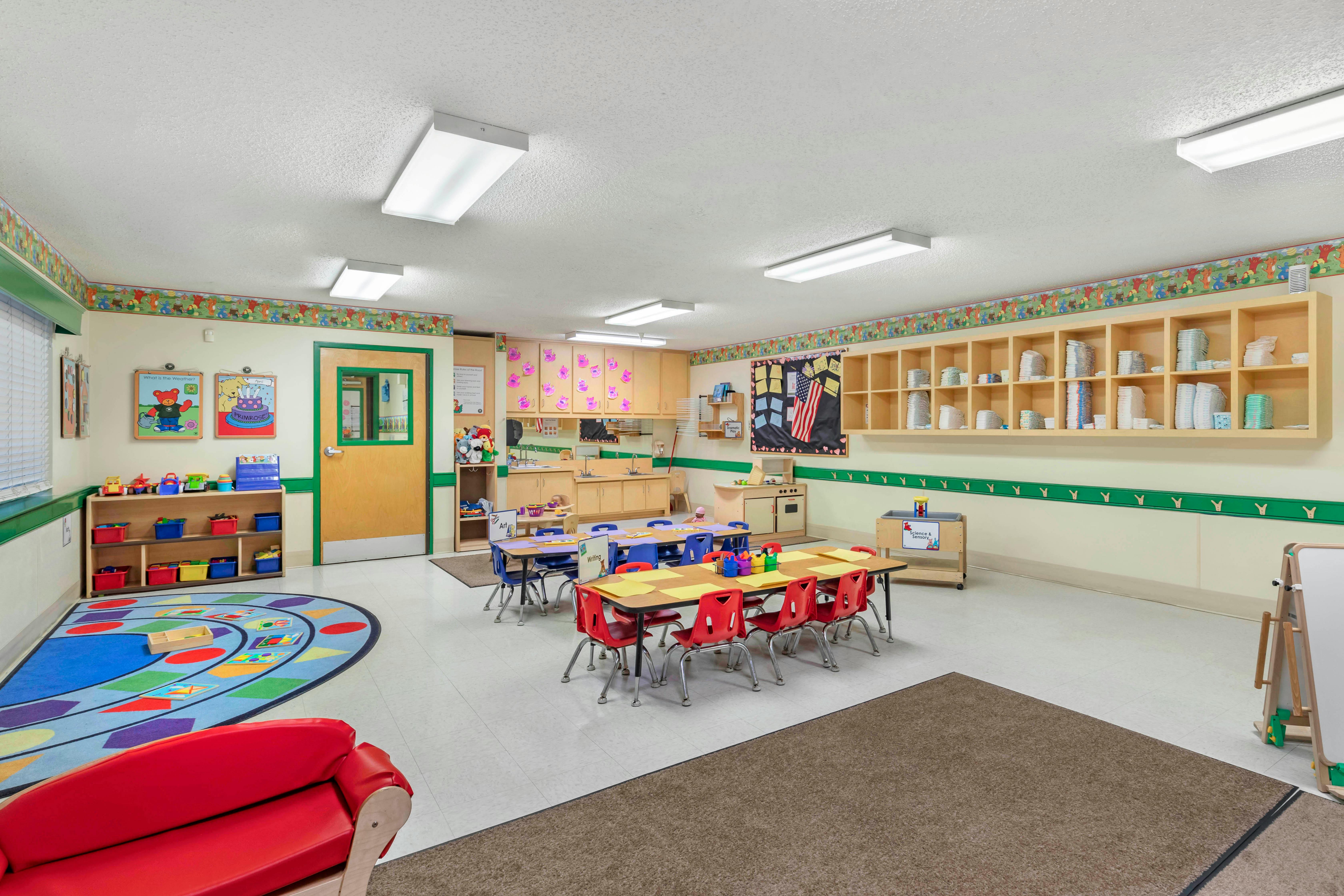 Classroom with tables, chairs, toys, and a science & sensory station