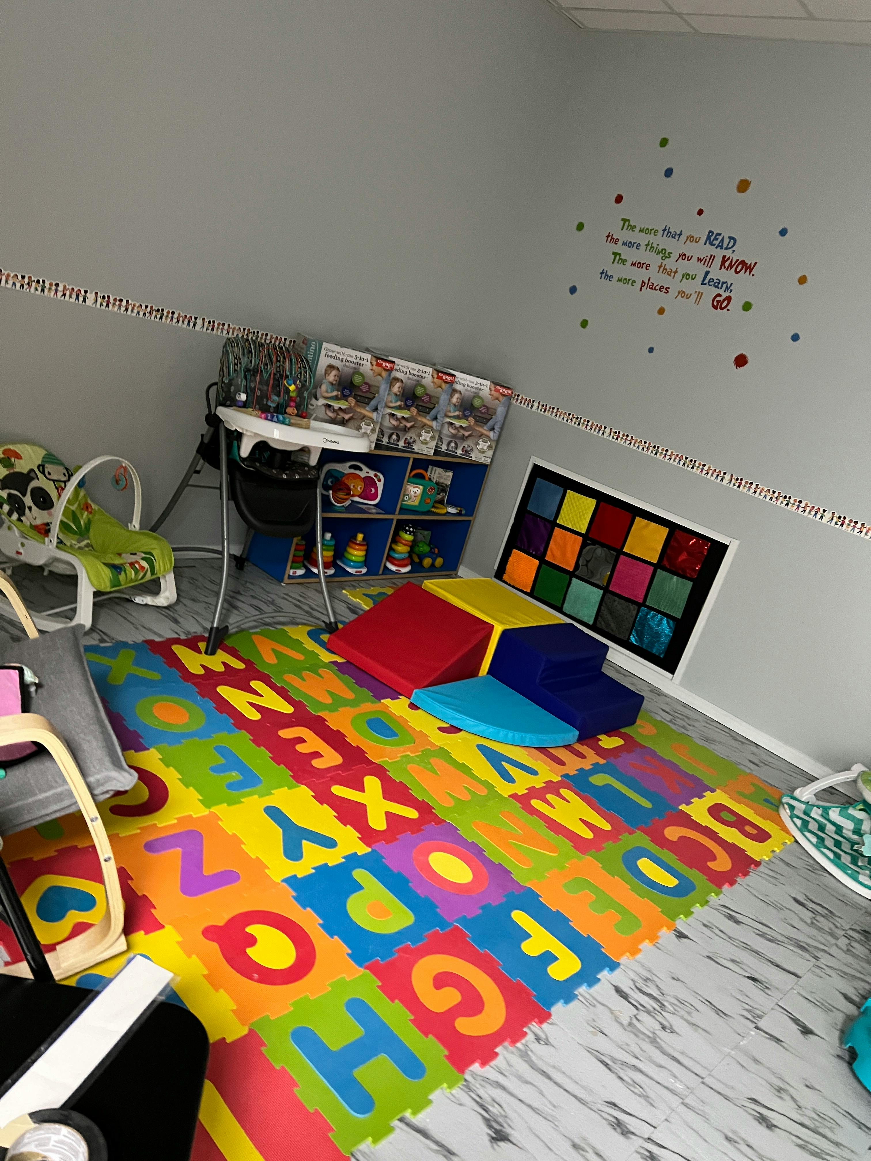 Playroom with colorful alphabet floor mats and soft play equipment
