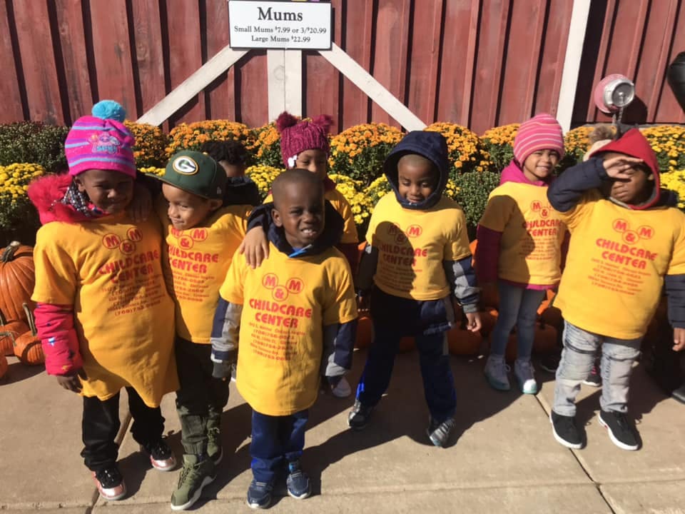 Group of children in yellow shirts standing outdoors