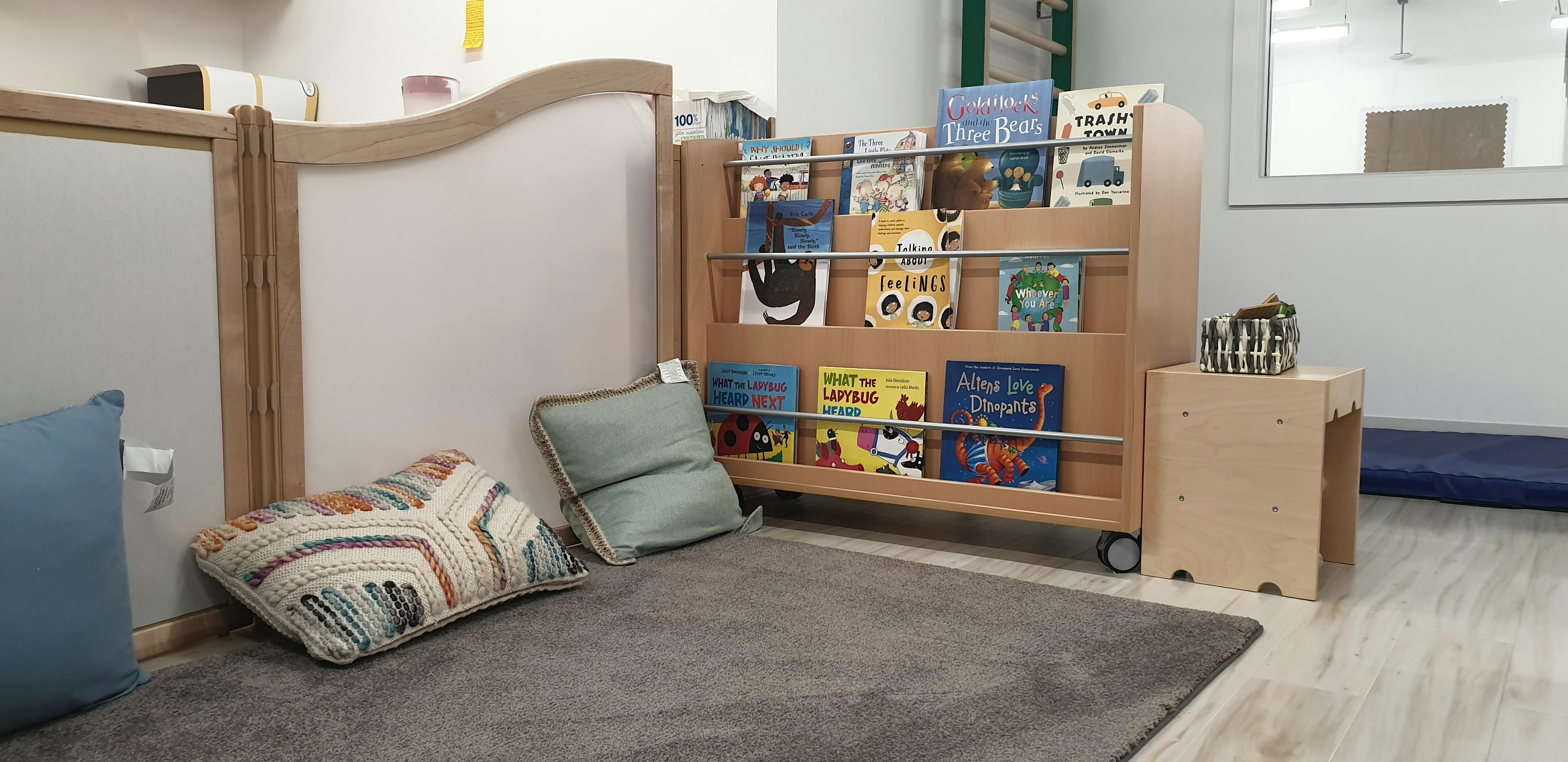 Children's book display with pillows on a rug
