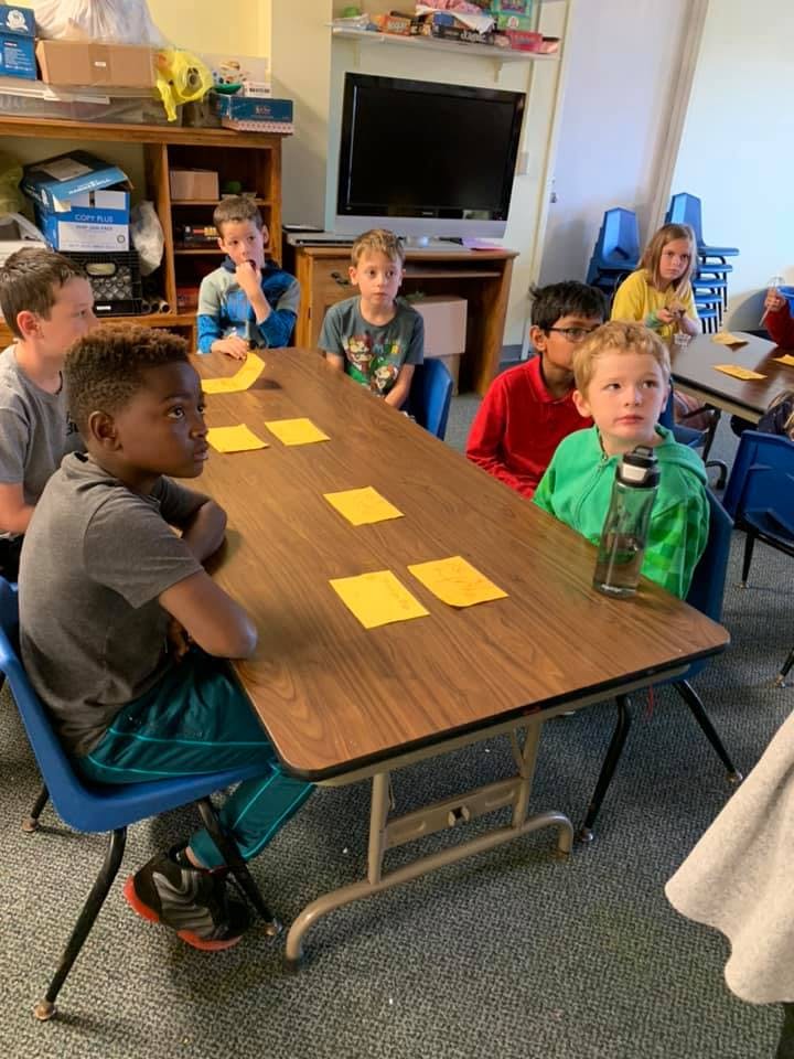 Children sitting at tables in a classroom