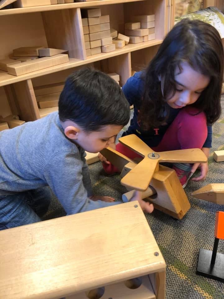 Two children playing with wooden toys