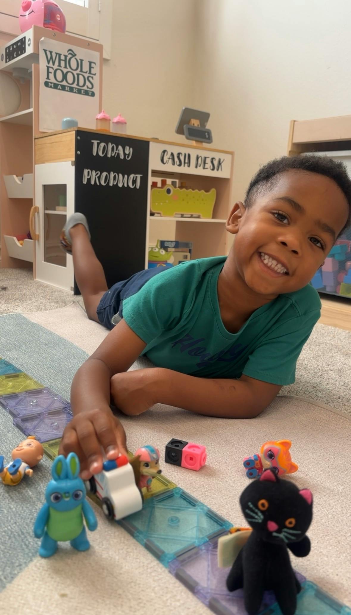 Child lying on the floor playing with small toy figures