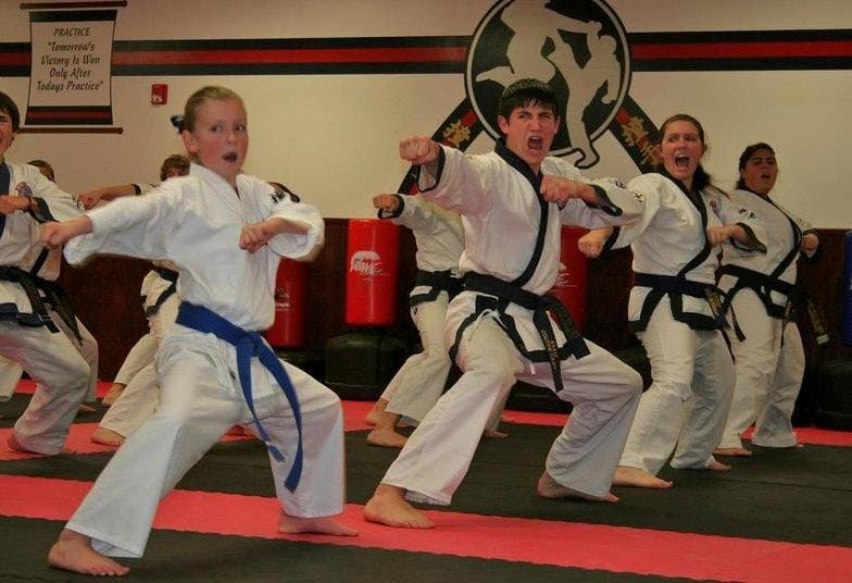 People in martial arts uniforms practicing stances